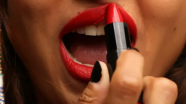 Frau trägt knallroten Lippenstift auf – Dirty Talk am Telefon